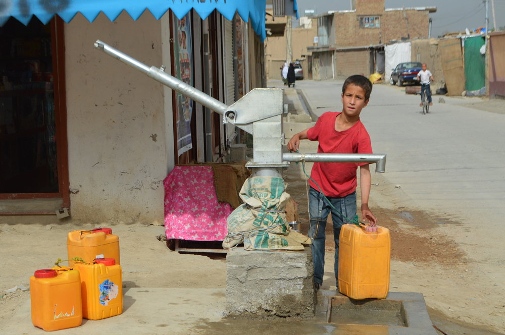 Water scarcity in Kabul, a child is filling his pots with  a hand pump in Kabul city : Photo by News Lens Pakistan/